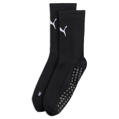 A pair of black crew socks with white Puma logos, ribbed ankles, and grey non-slip grip dots on the soles, set against a black background.
