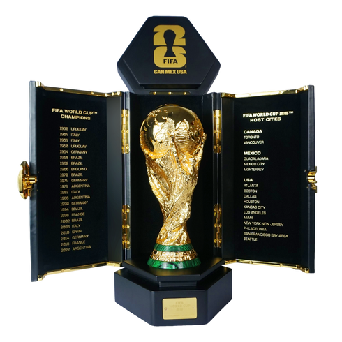 Gold FIFA World Cup trophy in an open black case. Panels list past tournament winners and the 2026 host cities across Canada, Mexico, and the USA.