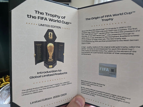 A certificate for a limited edition FIFA World Cup trophy replica, edition 0358/2026. It features a photo of the trophy, its history, and an official FIFA hologram.