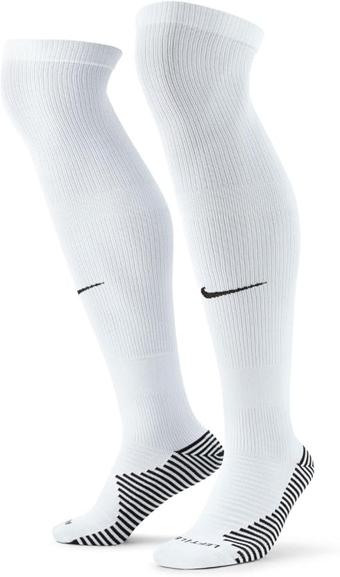 A pair of white Nike knee-high athletic socks featuring black swooshes on the shins and black-and-white striped grip patterns on the heels and soles.