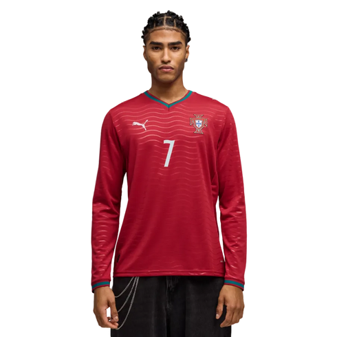 A man models a red long-sleeved Portugal soccer jersey with a white number 7, a Puma logo, and teal trim against a black background.
