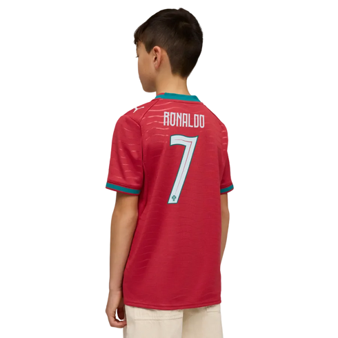 Back view of a boy wearing a red soccer jersey with "RONALDO 7" on the back and light-colored pants, set against a black background.