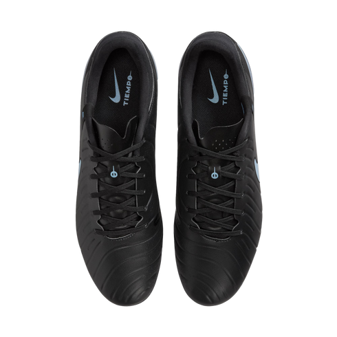 Overhead view of black Nike Tiempo soccer cleats on a black background, showing light blue logos on the inner soles.