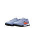 A pair of light blue Nike turf soccer shoes featuring a bright orange swoosh and black rubber soles, set against a black background.