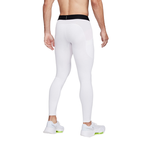 Rear view of a person in white Nike Pro compression leggings with a side pocket and white athletic sneakers, shown against a white background.