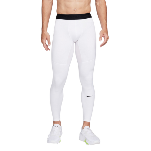 A man from the waist down wearing white Nike Pro compression leggings and white sneakers against a white background.