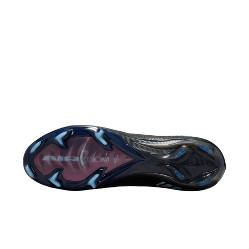Underside of a black soccer cleat featuring light blue studs and a translucent pink "AIR ZOOM" window on the forefoot, shown against a black background.