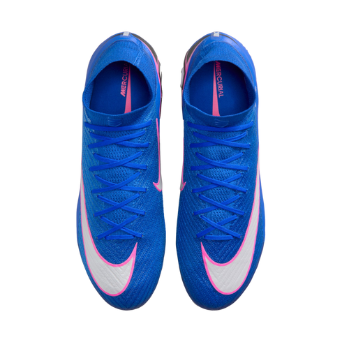 Top-down view of bright blue Nike Mercurial soccer cleats featuring white swooshes outlined in pink. The shoes have matching blue laces and are isolated against a black background.