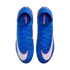 Top-down view of bright blue Nike Mercurial soccer cleats featuring white swooshes outlined in pink. The shoes have matching blue laces and are isolated against a black background.