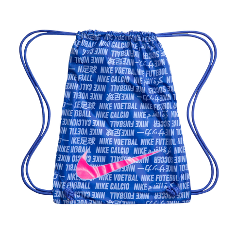 A blue Nike drawstring bag featuring a white multilingual text pattern and a large, vibrant pink Nike swoosh logo on the front.
