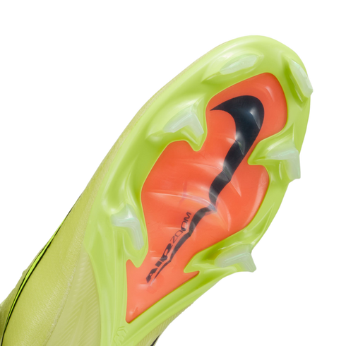 The sole of a neon yellow Nike football boot with translucent studs and an orange center plate featuring a black swoosh and "AIR ZOOM" text.