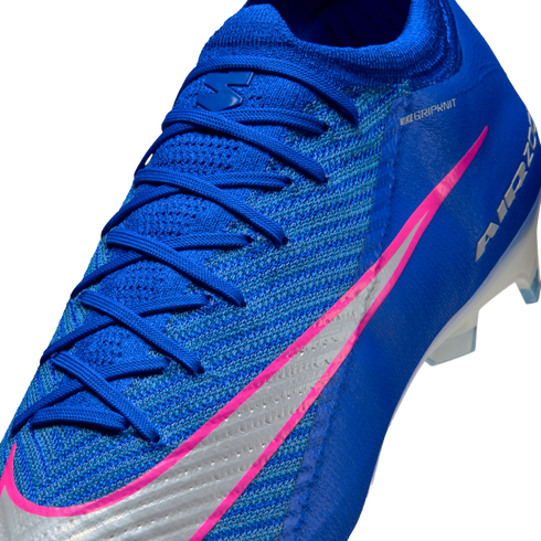 Close-up of a blue Nike soccer cleat featuring a vibrant pink and silver swoosh, blue laces, and a textured knit upper against a black background.