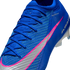 Close-up of a blue Nike soccer cleat featuring a vibrant pink and silver swoosh, blue laces, and a textured knit upper against a black background.