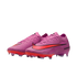 Pair of pink Nike Air Zoom soccer cleats with a vibrant red swoosh and sole plate, isolated on a black background.