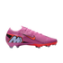 A pink Nike Mercurial soccer cleat featuring an orange swoosh and a large light blue "M" logo on the heel, set against a black background.