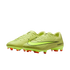 Neon yellow Nike soccer cleats with a textured upper, black swoosh, and orange studs, set against a black background.