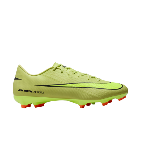 A side profile of a neon yellow Nike Air Zoom soccer cleat with a large black swoosh and orange studs, set against a solid black background.