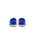 Rear view of blue Nike Mercurial turf shoes with pink accents and white outsoles, set against a solid black background.