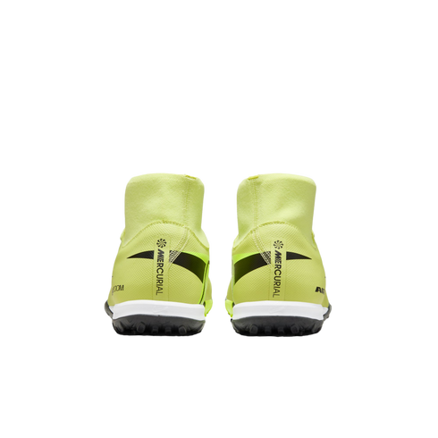 Rear view of neon yellow Nike Mercurial soccer shoes on a black background, featuring black branding on the heels, white midsoles, and black turf outsoles.