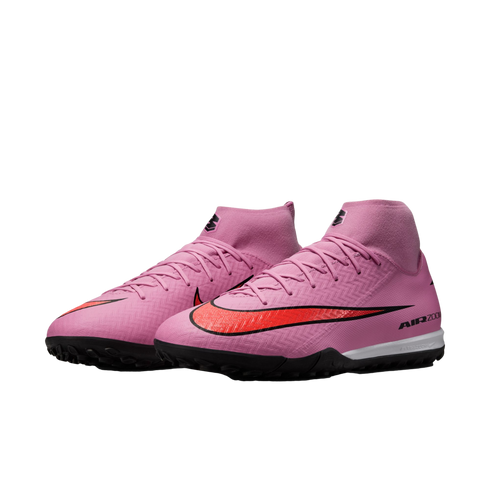 A pair of pink Nike Mercurial Superfly soccer turf shoes with a bold red swoosh, high-top collar, and black outsole on a black background.
