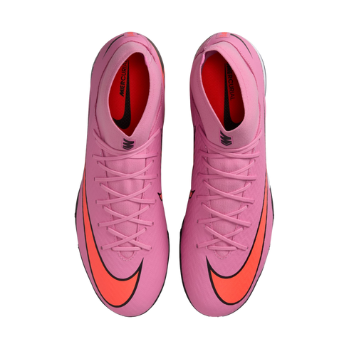 Top-down view of pink Nike Mercurial soccer cleats with bright orange swooshes and matching laces, set against a solid black background.
