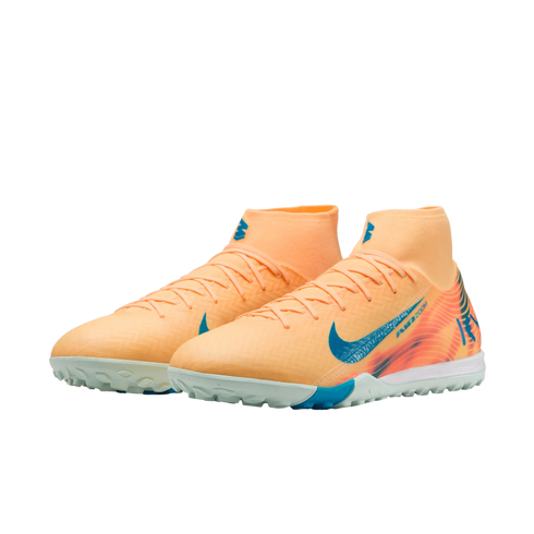 Pair of light orange Nike soccer turf shoes with blue Nike swoosh logos and high-top sock collars.