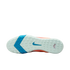 Sole of a Nike soccer shoe with a mint green and blue textured tread pattern and a blue swoosh in the center, set against a black background.