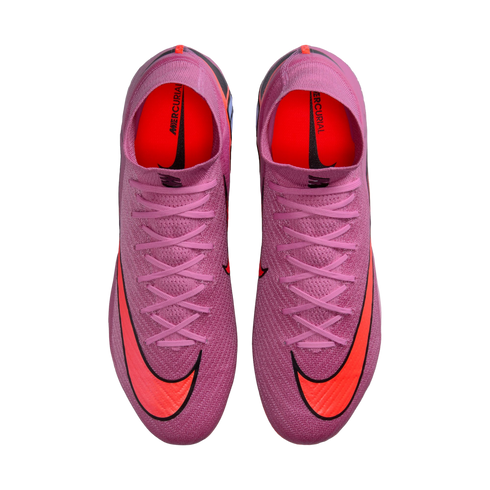 Top-down view of pink textured Nike Mercurial soccer cleats with large orange swooshes and pink laces, set against a black background.