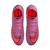 Top-down view of pink textured Nike Mercurial soccer cleats with large orange swooshes and pink laces, set against a black background.