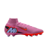 Pink Nike Mercurial soccer cleat with orange swoosh, large blue 'M' logo on the heel, and high-top collar, set against a black background.