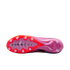The soleplate of a pink Nike Air Zoom soccer cleat with red accents and white circular studs against a black background.