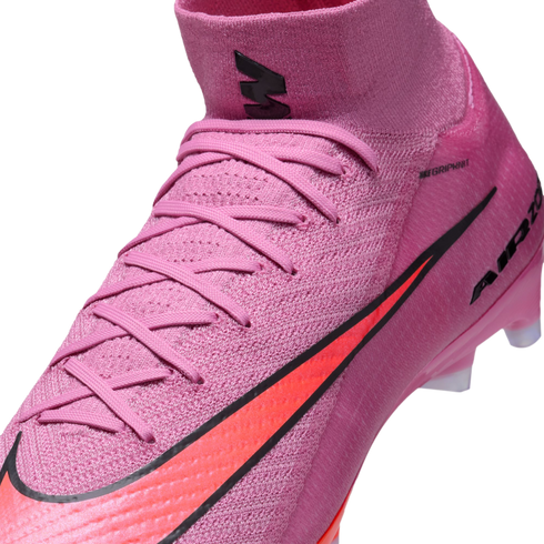 Close-up of a pink Nike soccer cleat featuring an orange swoosh and a high-top Flyknit collar.