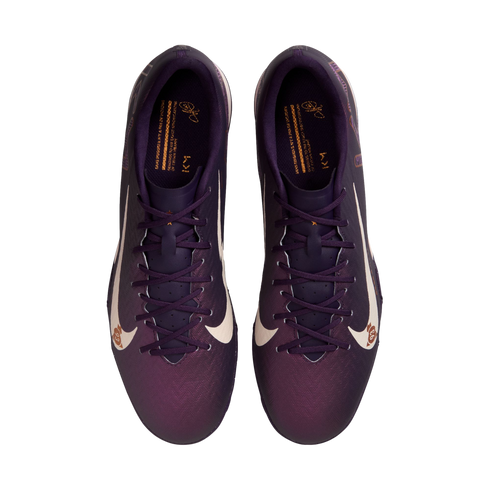 Top-down view of purple Nike soccer cleats with large white swooshes and gold interior accents on a white background.