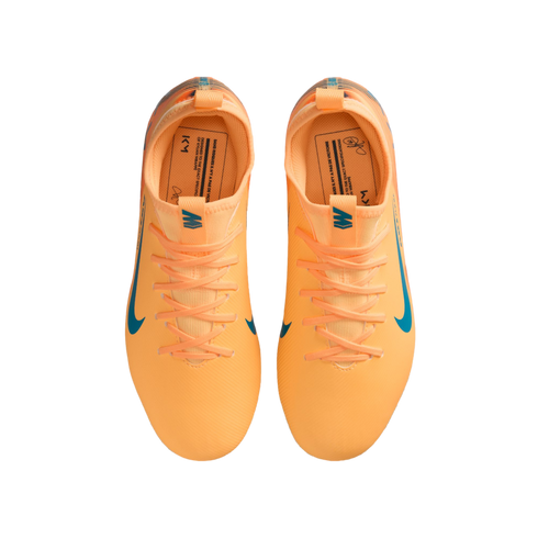 Top-down view of bright orange Nike soccer cleats with blue accents and Kylian Mbappé's "KM" branding on a black background.