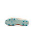 The underside of an orange Nike soccer cleat, featuring a light blue soleplate with bright blue studs against a black background.