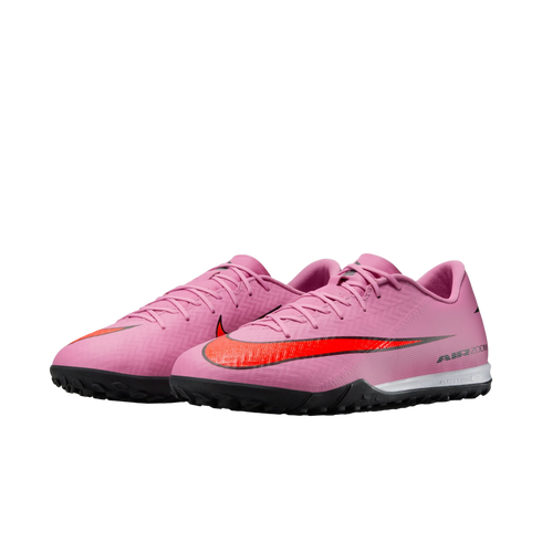 A pair of pink Nike Air Zoom turf soccer shoes featuring a bright red swoosh and black textured soles.