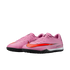 A pair of pink Nike Air Zoom turf soccer shoes featuring a bright red swoosh and black textured soles.