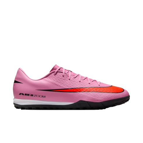 Profile view of a pink Nike Air Zoom turf soccer shoe with a large red swoosh, white midsole, and black outsole.