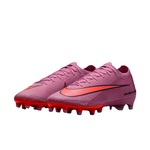 A pair of purple Nike Air Zoom soccer cleats with bright orange Nike swooshes and orange studded soles, set against a solid black background.