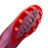 Close-up of a pink Nike soccer cleat's soleplate with bright orange accents and translucent conical studs, showing a visible Air Zoom unit inside.