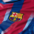 Close-up of the FC Barcelona club crest on a blue and maroon striped jersey with a textured fabric.