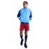 Man modeling a light blue and navy FC Barcelona track jacket, red shorts, and tall blue socks against a solid black background.