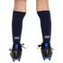 Rear view of a person's lower legs wearing navy blue USA soccer socks and black Nike Mercurial cleats with bright blue accents against a white background.