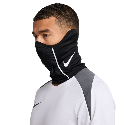 Man wearing a black Nike neck gaiter with a white swoosh logo and a white athletic long-sleeve shirt against a black background.