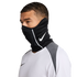 Man wearing a black Nike neck gaiter with a white swoosh logo and a white athletic long-sleeve shirt against a black background.