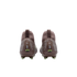 Rear view of two brown Nike Mercurial soccer cleats with silver dot patterns, "Zm Air" logos on the heels, and lime green studs against a black background.