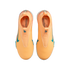 Top-down view of bright orange laceless Nike soccer shoes with teal accents and "KM" branding on the insoles, set against a black background.