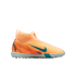 Peach Nike laceless turf soccer shoe with teal accents and a high-top sock-like collar, shown against a solid black background.