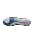 Sole of a Nike soccer cleat with clear studs, a white and blue base, and a pink swoosh against a black background.