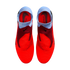 A top-down view of a pair of red and light blue laceless Nike Phantom football boots against a solid black background.